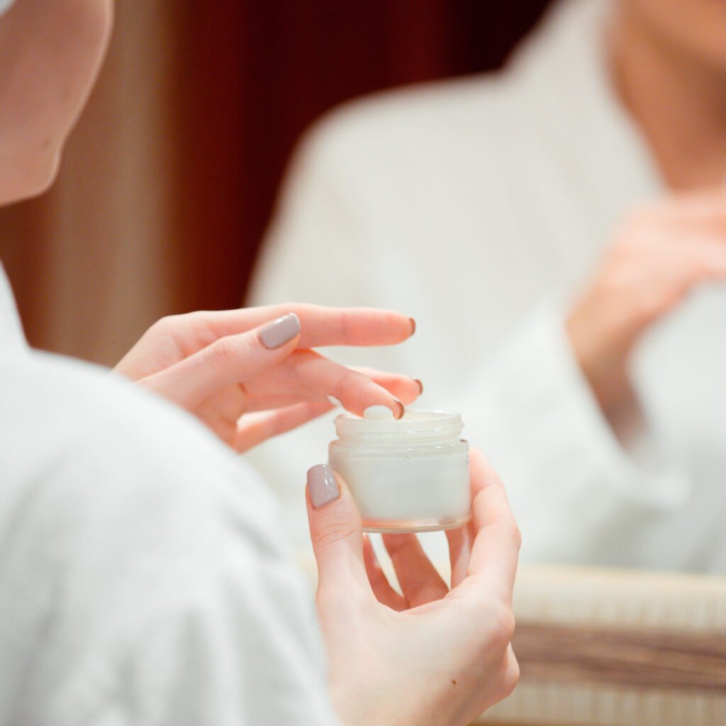 Top 10 Skin Whitening Creams in Pakistan 3 woman taking face cream with her finger bathroom